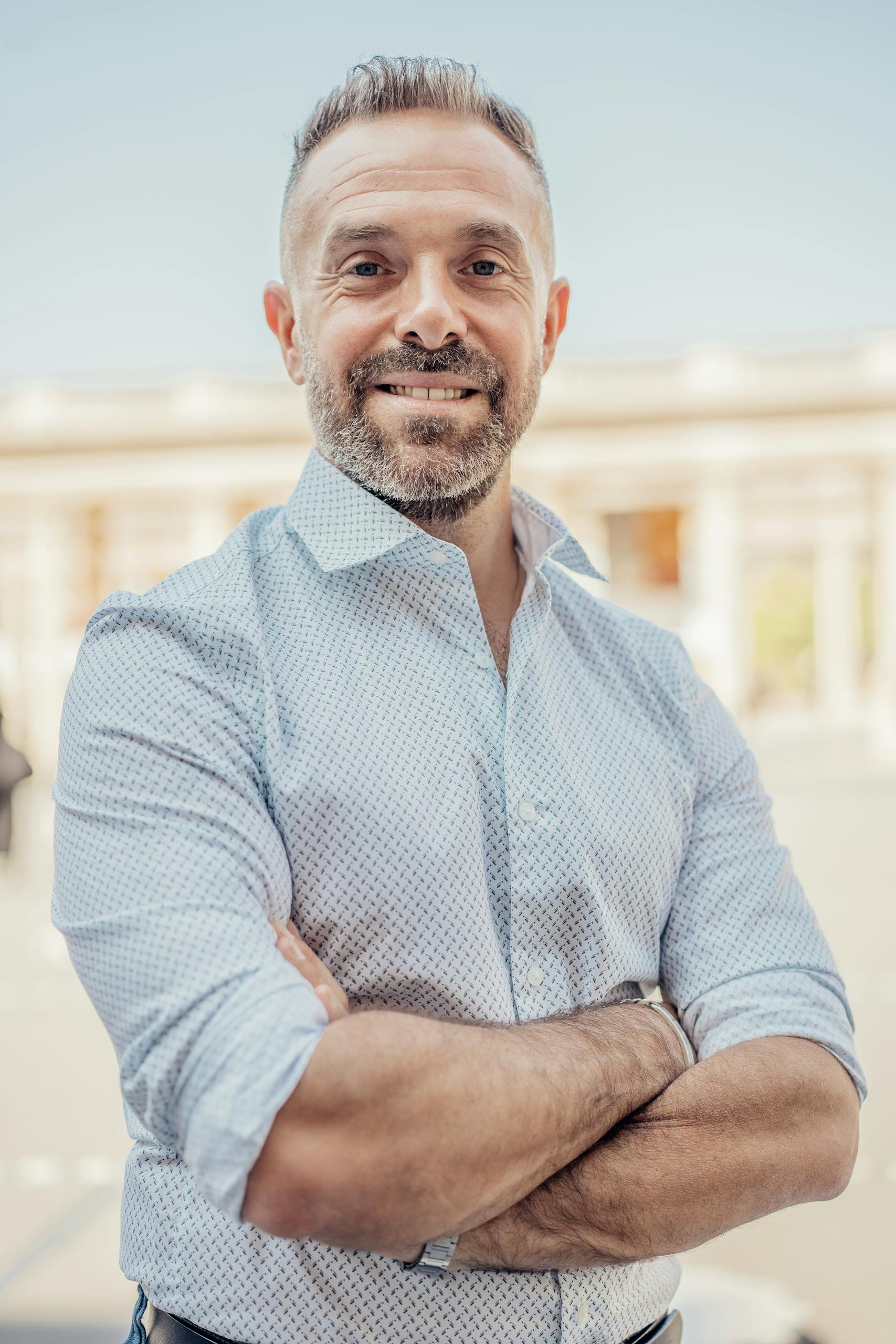 Portrait of a confident businessman outside in Paris, showcasing professional and friendly demeanor.